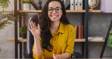 Happy millennial woman wave talk on webcam or having conversation for job video call